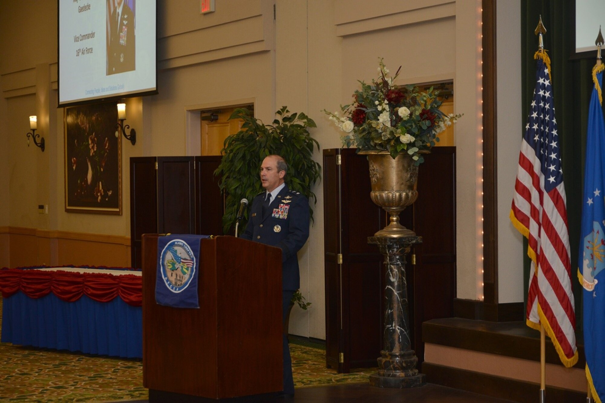 Maj. Gen. in official blues uniform speaks in front of a podium.