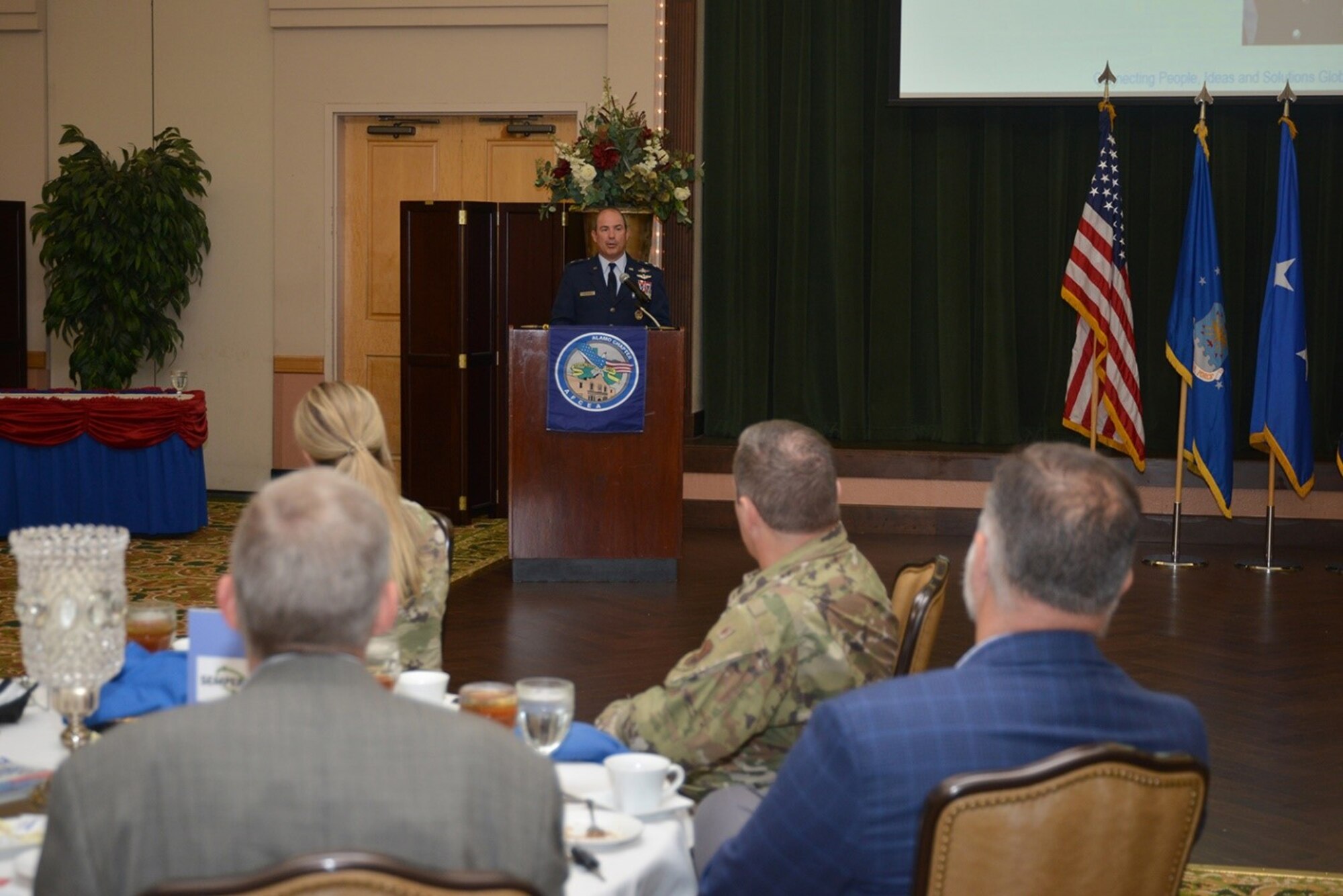 Maj. Gen. in official blues uniform speaks in front of a podium.