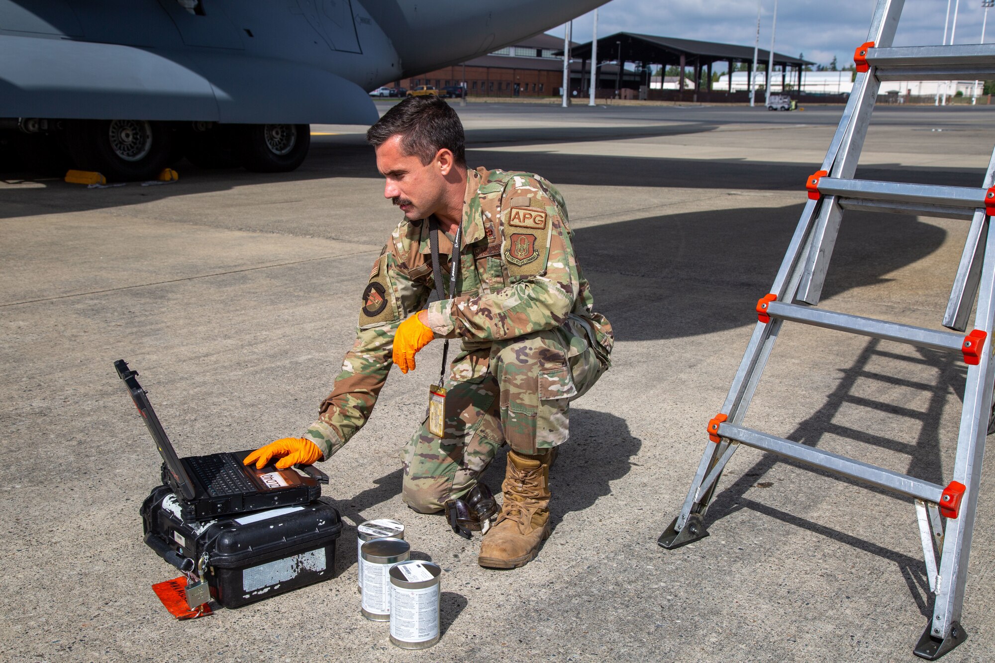 Airman checks complete on flight line underneath an aircraft