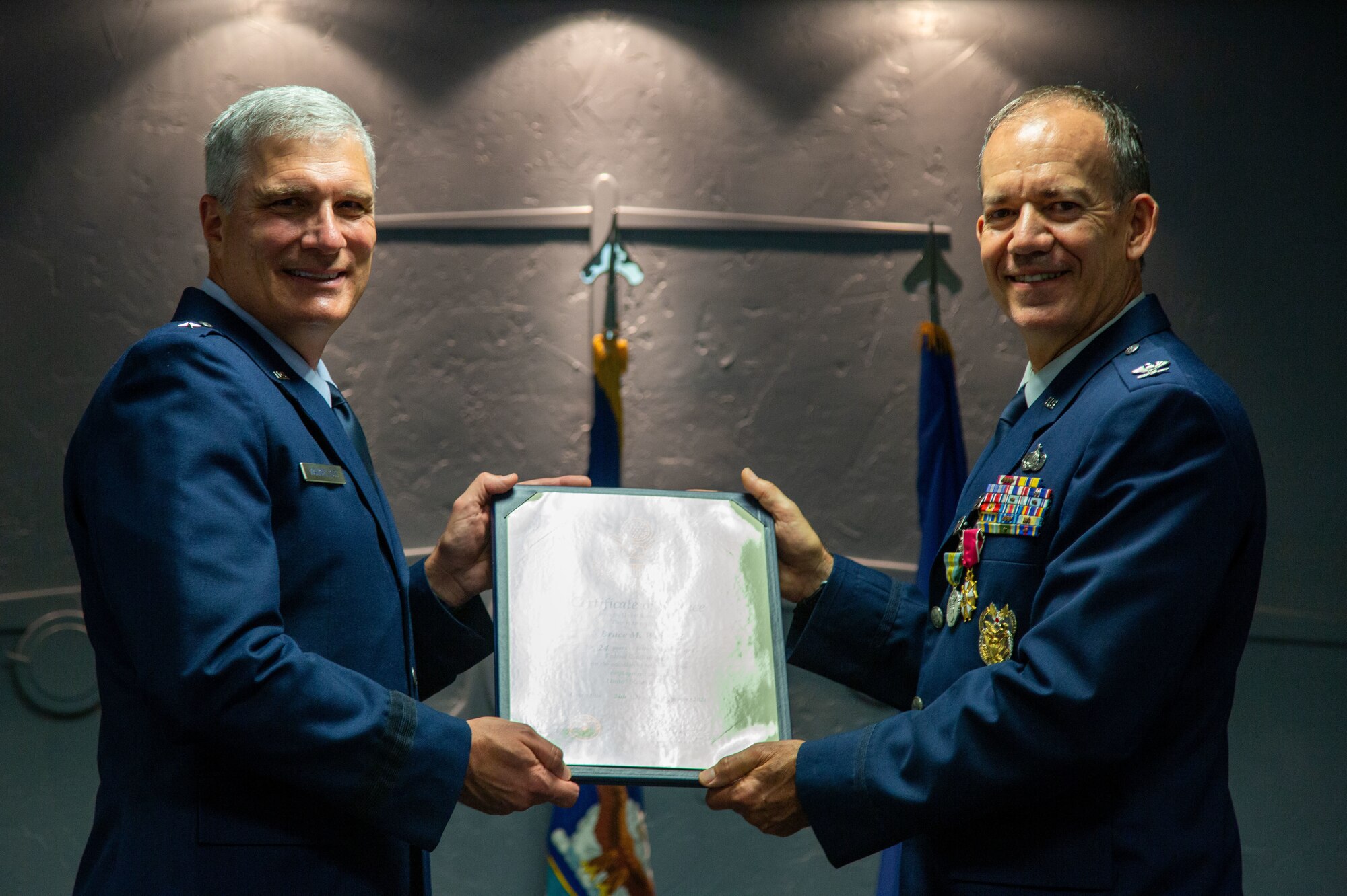 Two airmen hold a certificate.