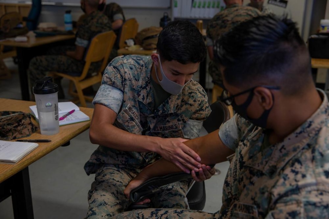 U.S. Marine Corps Lance Cpl. Alejandro Rosalesflores, left, and, Cpl. Henry Ortega, right, both electricians with Engineer Support Company, 9th Engineer Support Battalion, 3rd Marine Logistics Group, practice applying a splint during a Tactical Combat Causality Care Course on Camp Hansen, Sept. 9, 2021. 9th ESB conducts TCCC classes to allow more Marines to become certified in combat lifesaving, a skill Lt. Col. Marcus Gillett, battalion commander of 9th ESB, plans for every Marine to have in the near future. 3rd MLG, based out of Okinawa, Japan, is a forward deployed combat unit that serves as III MEF’s comprehensive logistics and combat service support backbone for operations throughout the Indo-Pacific area of responsibility.
