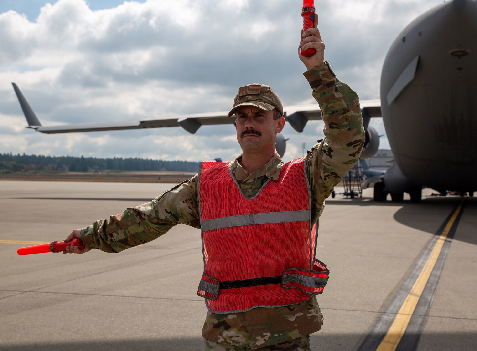 Airman uses signals to marshal aircraft.