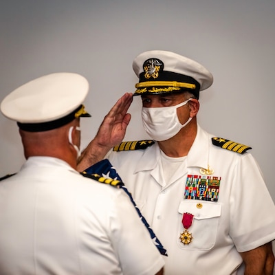 After 38 years of naval service, Capt. Keith Dowling, right, receives a U.S. flag during his retirement ceremony, Sept. 22.  The ceremony was held during a change of command for the Center for Explosive Ordnance Disposal and Diving (CEODD), where Dowling concluded his career as CEODD’s commanding officer.