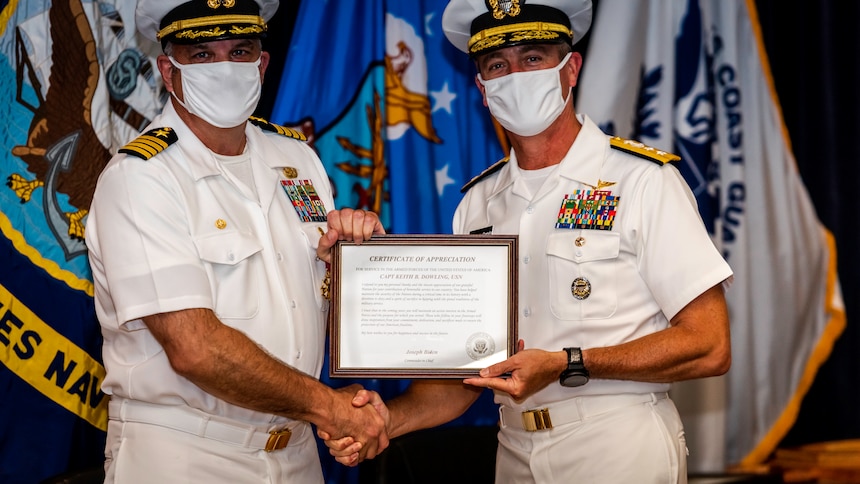 Rear Adm. Pete Garvin, right, commander, Naval Education and Training Command, presents Capt. Keith Dowling with a presidential letter of appreciation during his retirement ceremony, Sept. 22. Dowling retired after nearly 38 years of service in the U.S. Navy.
