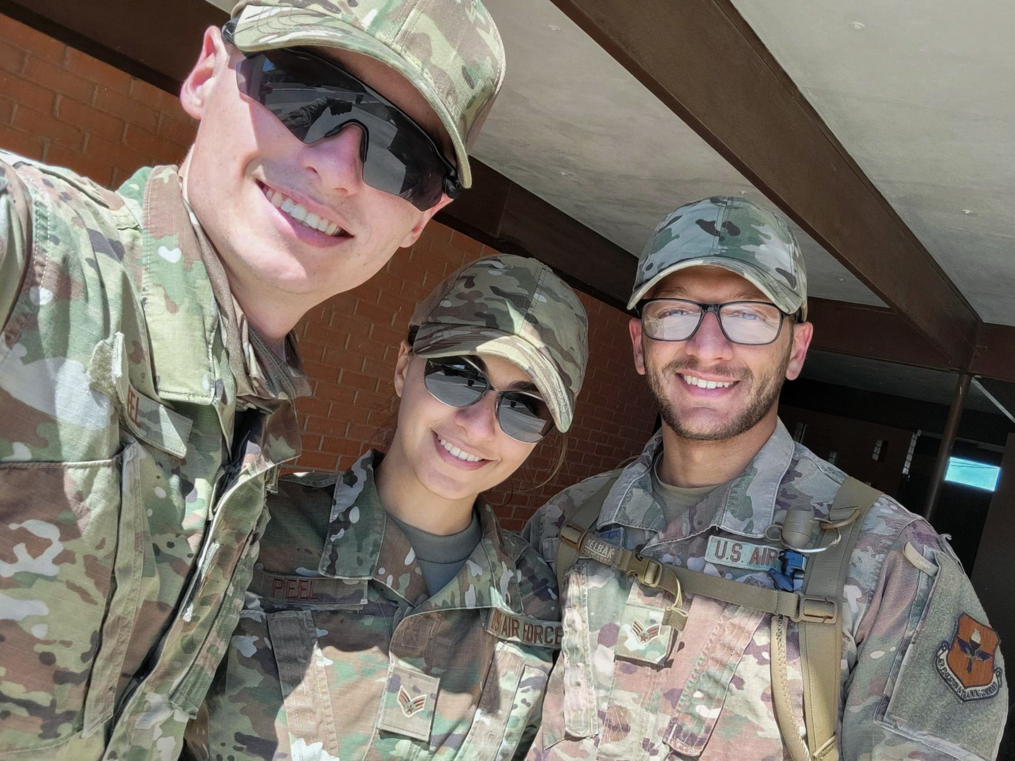 Senior Airman Israa Peel, center, Task Force-Holloman linguist deployed from Dyess Air Force Base, Texas; Israa's brother, Senior Airman Ahmed Kamil, right, TF-H heating, ventilation, air conditioning and refrigeration journeyman deployed from Holloman AFB, New Mexico; and her husband Senior Airman Daniel Peel, TF-H augmentee deployed from Dyess AFB; pose for a photo after volunteering to join TF-H in support of Operation Allies Welcome Sept. 5, 2021 on Holloman AFB. Both Israa and Kamil came to the U.S. as refugees from Iraq in 2009. The Department of Defense, through U.S. Northern Command, and in support of the Department of State and Department of Homeland Security, is providing transportation, temporary housing, medical screening, and general support for at least 50,000 Afghan evacuees at suitable facilities, in permanent or temporary structures, as quickly as possible. This initiative provides Afghan evacuees essential support at secure locations outside Afghanistan. (Courtesy photo)