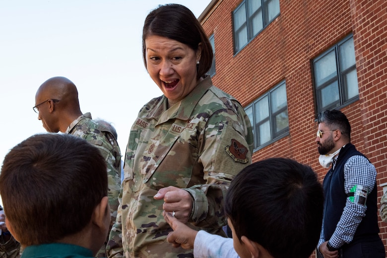 Chief Master Sergeant of the Air Force JoAnne Bass fist bumps Afghan children during a visit to Liberty Village on Joint Base McGuire-Dix-Lakehurst, New Jersey, Sept. 25, 2021. The Department of Defense, through U.S. Northern Command, and in support of the Department of Homeland Security, is providing transportation, temporary housing, medical screening, and general support for at least 50,000 Afghan evacuees at suitable facilities, in permanent or temporary structures, as quickly as possible. This initiative provides Afghan personnel essential support at secure locations outside Afghanistan. (U.S. Air Force photo by Staff Sgt. Jake Carter)
