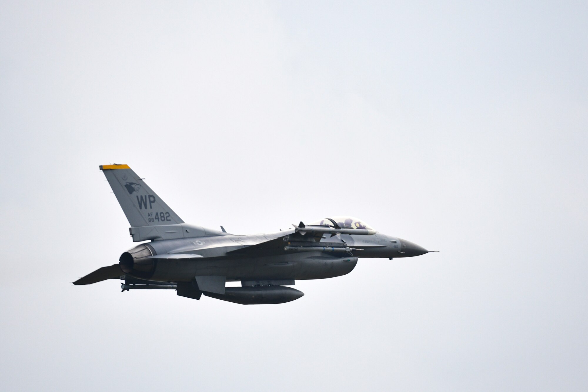 A jet flies over a military base.