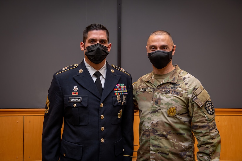 two men in army uniforms pose for a photo.