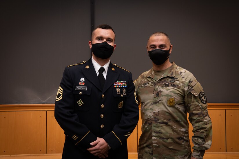 two men in army uniforms pose for a photo.