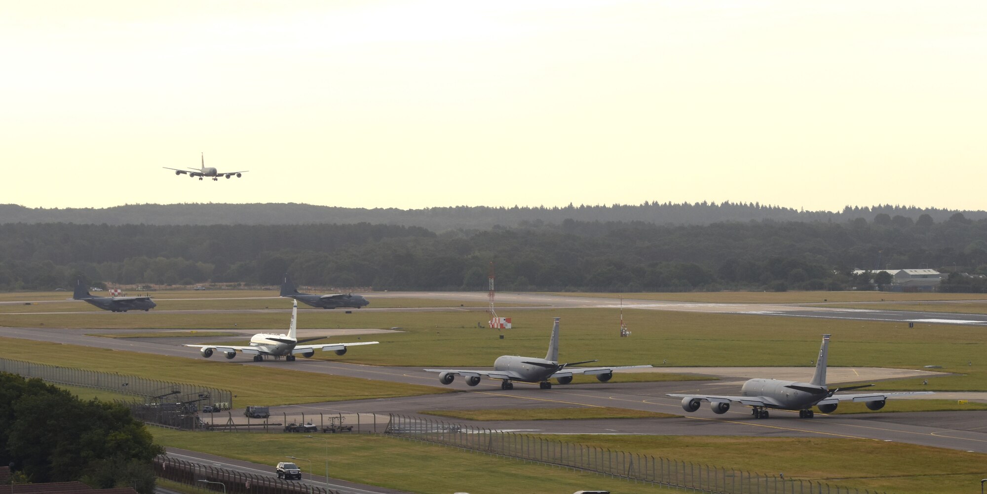 Team Mildenhall aircraft pause for a plane to land as they participate in an “elephant walk” at Royal Air Force Mildenhall Sept. 13, 2021. An elephant walk is a term used by the U.S. Air Force when multiple aircraft taxi together before takeoff. (U.S. Air Force photo by Karen Abeyasekere)