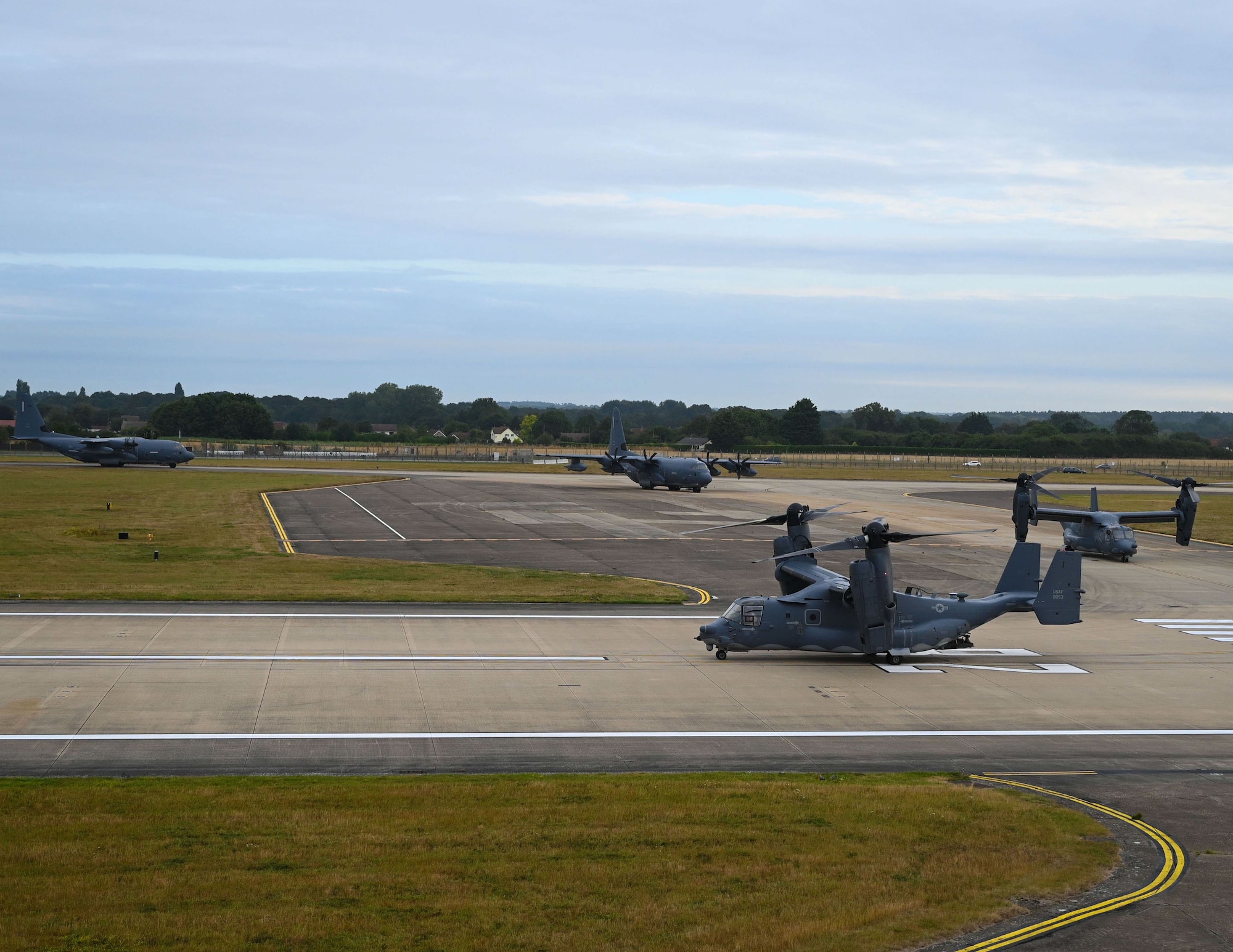 A CV-22 Osprey and two MC-130J Commando II aircraft taxi onto the runway as they prepare to lead the elephant walk at Royal Air Force Mildenhall, England, Sept. 13, 2021. An elephant walk is a term used by the U.S. Air Force when multiple aircraft taxi together before takeoff. (U.S. Air Force photo by Airman 1st Class Viviam Chiu).