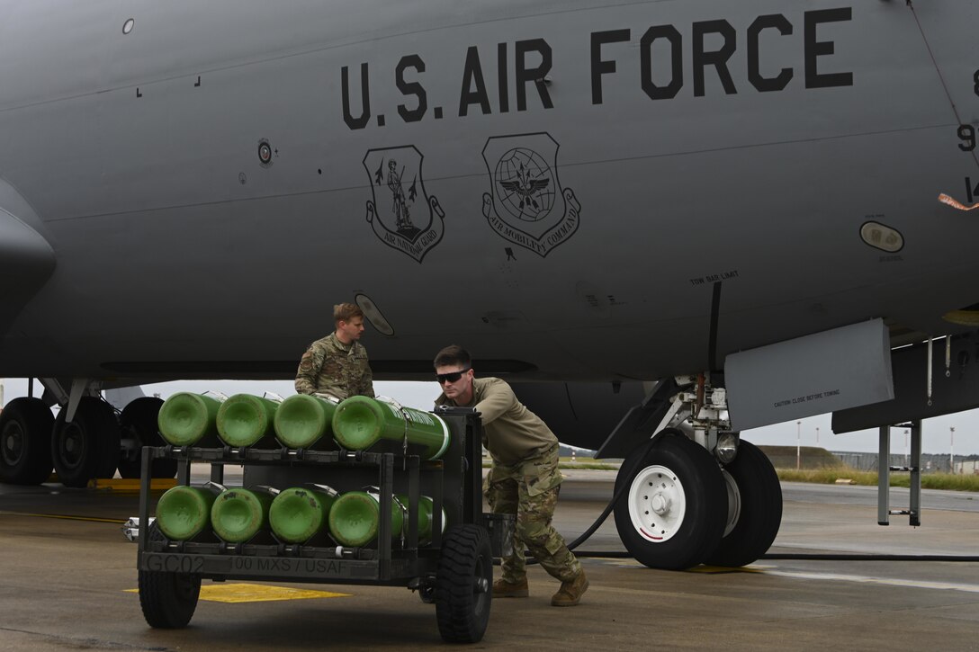 U.S. Air Force Staff Sgt. Lane Lucas, 100th Aircraft Maintenance Squadron crew chief, pushes a cart of oxygen tanks after refilling the oxygen supply of a KC-135 Stratotanker aircraft at Royal Air Force Mildenhall, England, Aug. 31, 2021. The 100th AMXS supports the Air Force's global reach mission by maintaining KC-135s, which provide air refueling capabilty throughout Europe and Africa. (U.S. Air Force photo by Senior Airman Joseph Barron)