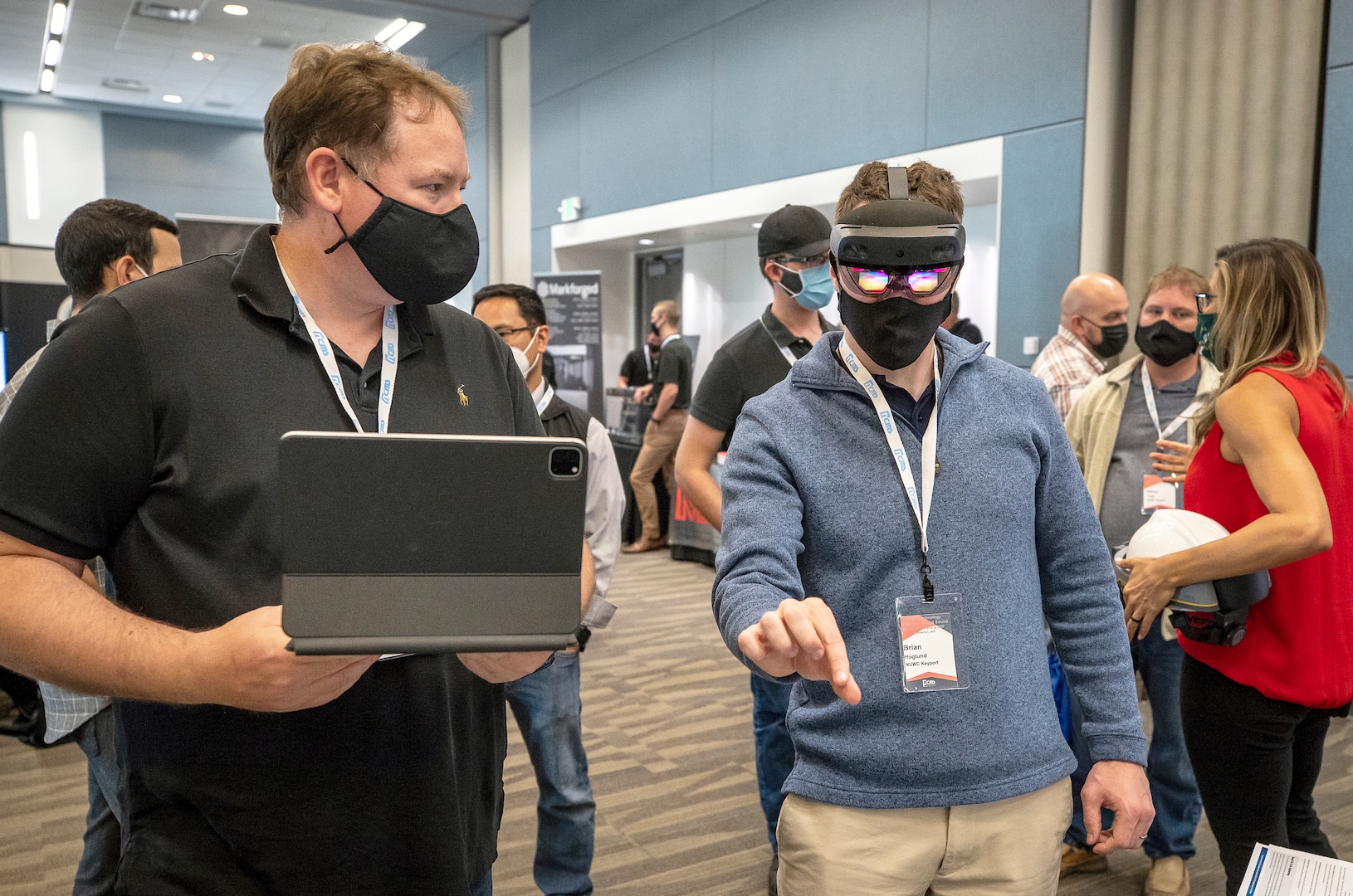 Lifecycle Engineering representative Cory Kozlowski, left, helps Brian Hoglund, a Keyport computer scientist, use a mixed-reality headset Wednesday, Aug. 25, 2021, during Puget Sound Naval Shipyard & Intermediate Maintenance Facility's 2021 Technology Showcase at the Kitsap Conference Center in Bremerton, Washington. (PSNS & IMF photo by Scott Hansen)