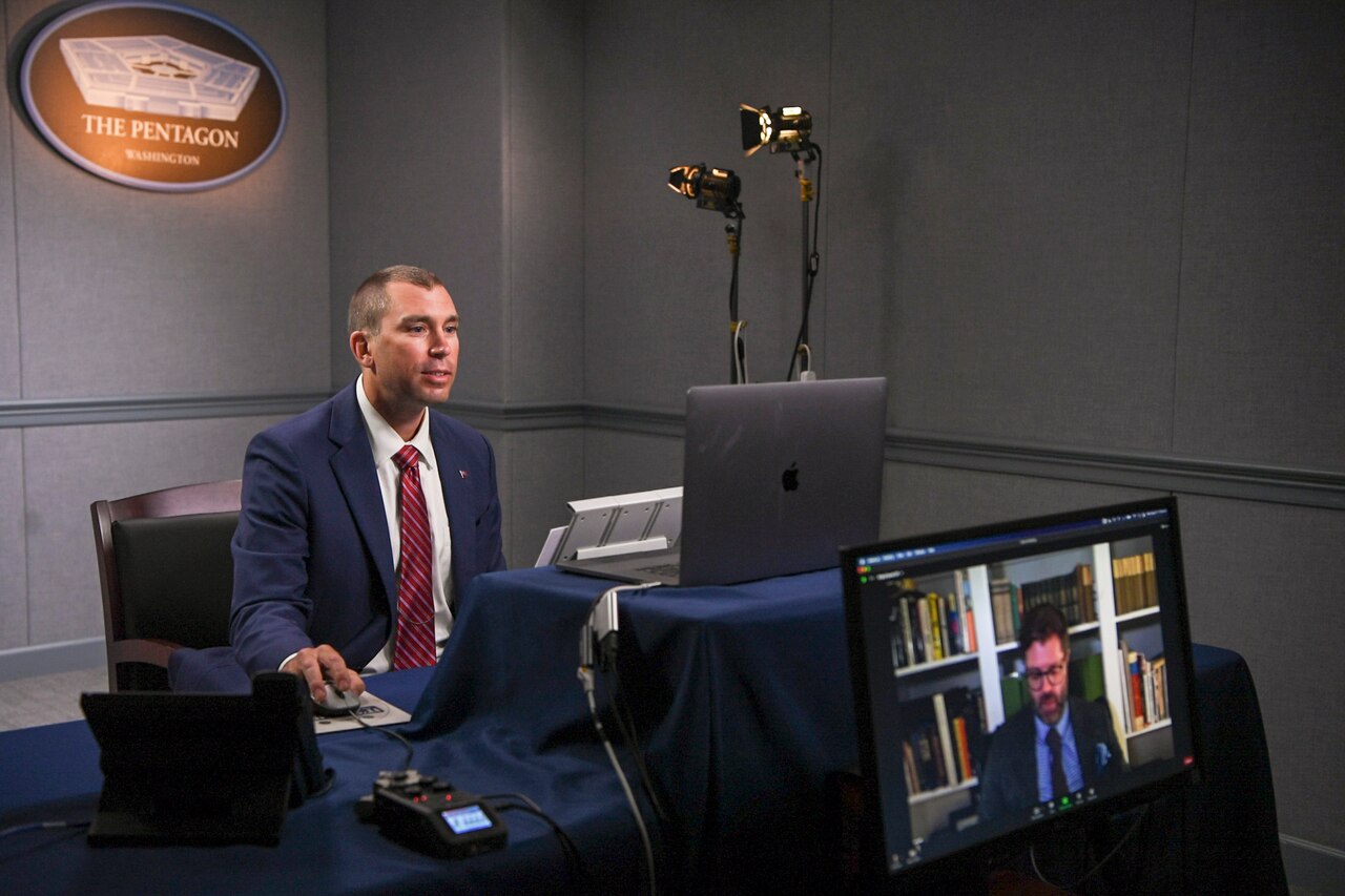 A  man sits in front of several computer monitors at the Pentagon.