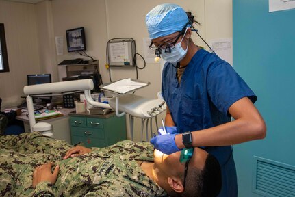 U.S. Navy Lt. Tanya Mullin, right, from Virginia Beach, Virginia, a dental officer assigned to the aircraft carrier USS John C. Stennis (CVN 74), conducts an annual cleaning and screening for Engineman 2nd Class Dallas Vaughn, from Fresno, California, on the floating accommodation facility, in Newport News, Virginia, Sept. 21, 2021. John C. Sten