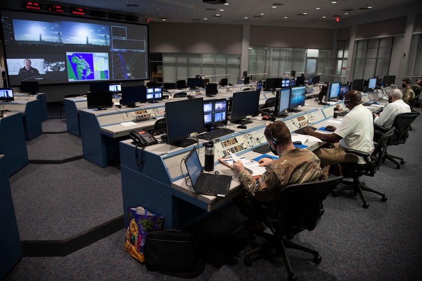 Personnel work in a space control room.