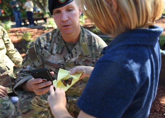 U.S. Air Force Master Sgt. Frank Lott, Second Air Force special warfare training production manager, watches his son, Oliver, release a butterfly during the Air Force Families Forever Fallen Heroes Butterfly Garden dedication ceremony at the marina park at Keesler Air Force Base, Mississippi, Sept. 24, 2021. The garden was created as a designated location where the families of our fallen heroes can find a serene area to pay tribute to their loved one as well as honoring our fallen service members. (U.S. Air Force photo by Kemberly Groue)