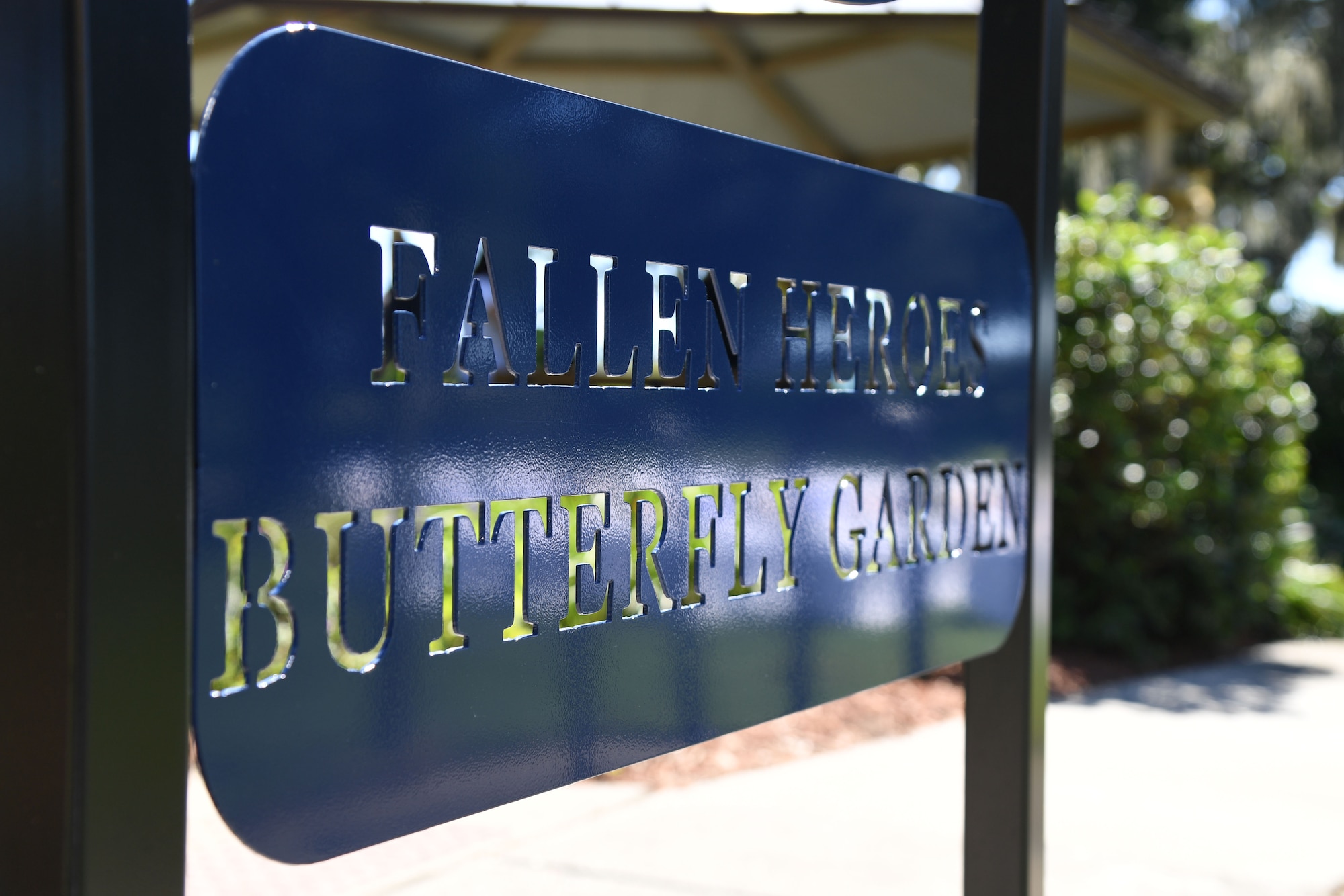 A metal entry sign is on display during the Air Force Families Forever Fallen Heroes Butterfly Garden dedication ceremony at the marina park at Keesler Air Force Base, Mississippi, Sept. 24, 2021. The garden was created as a designated location where the families of our fallen heroes can find a serene area to pay tribute to their loved one as well as honoring our fallen service members. (U.S. Air Force photo by Kemberly Groue)