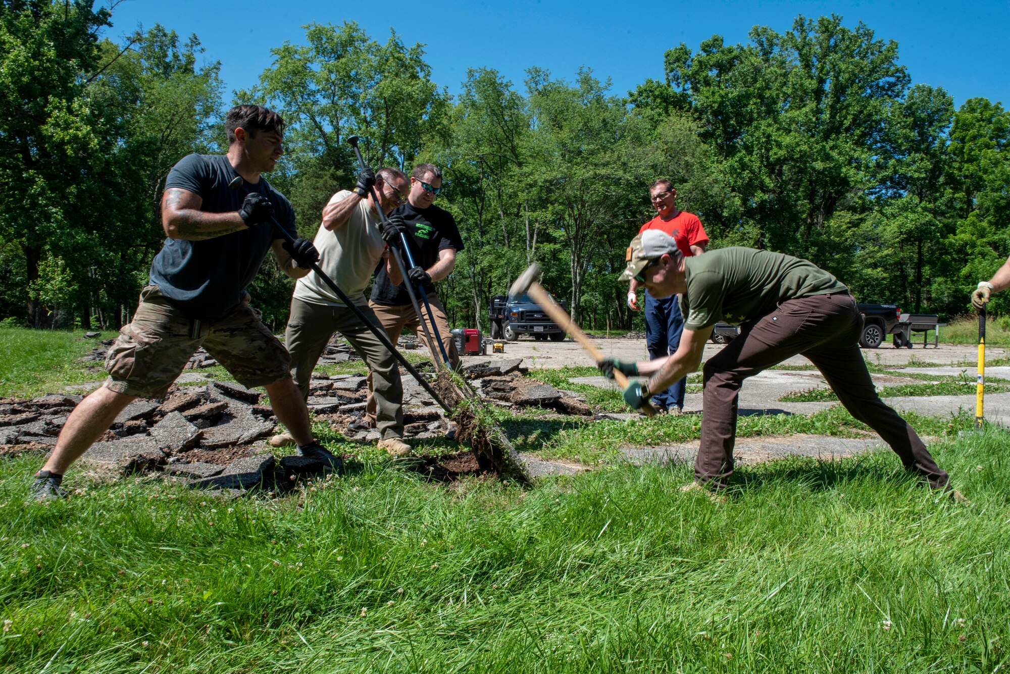 Men and women break up pavement.