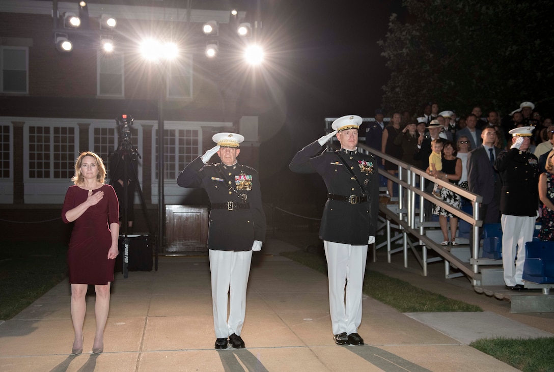 Deputy Defense Secretary Kathleen H. Hicks stands outside with hand over heart.