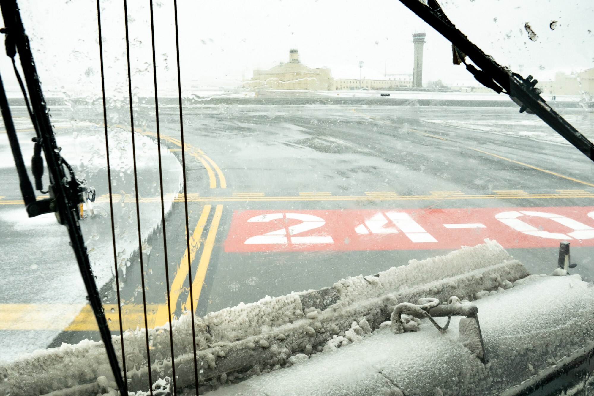 A 773d Civil Engineering Squadron snow sweeper clears the flight line in front of the Air Traffic Control tower after an early-season snowfall.