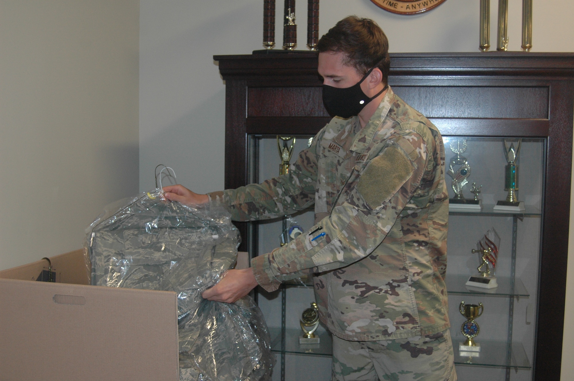 man placing clothing into a box