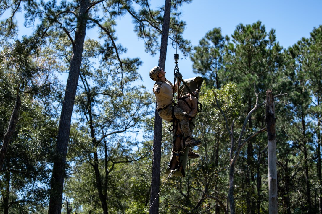 Photo of Airmen rappelling from a helicopter