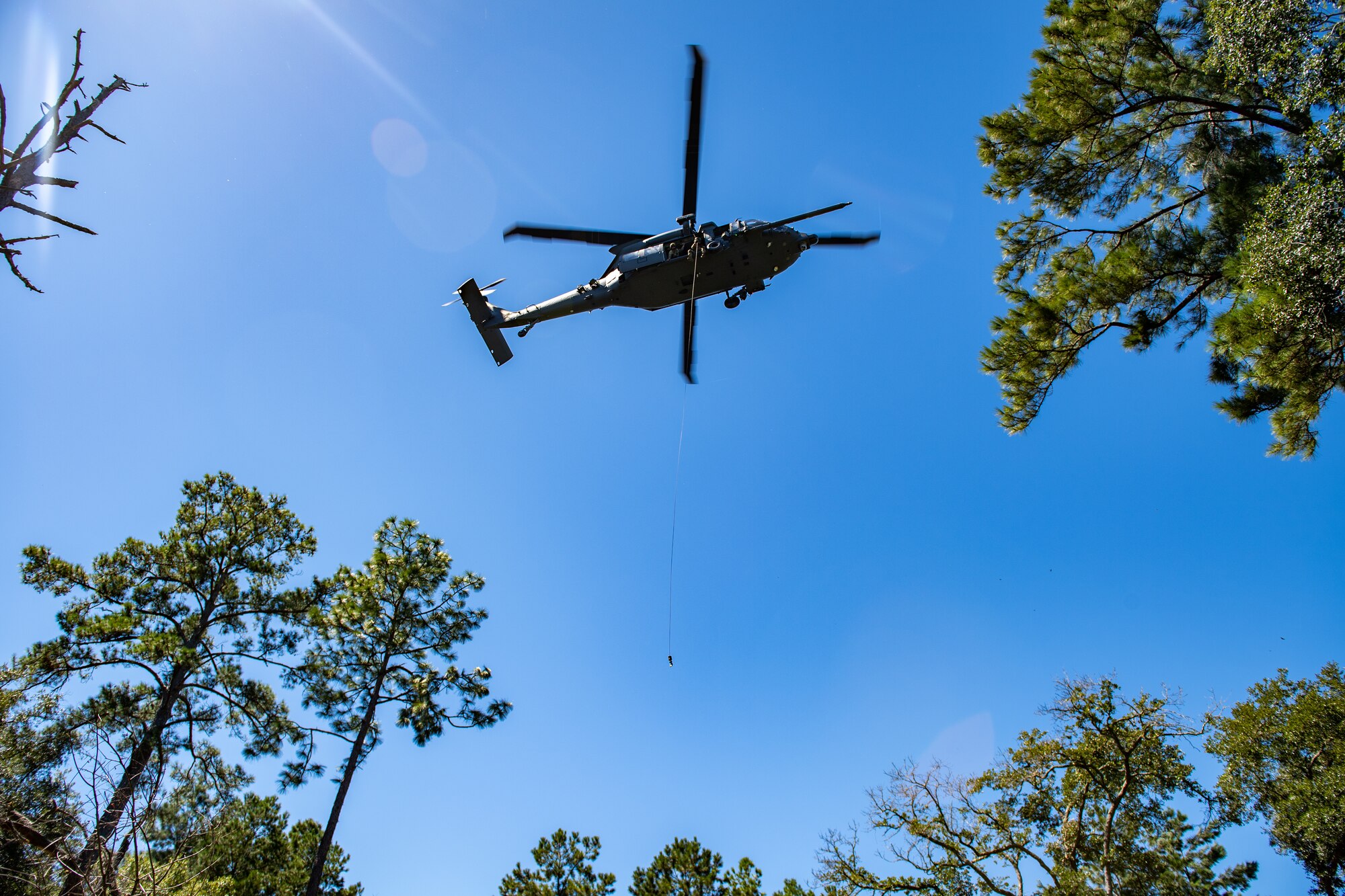 Photo of a helicopter flying over trees