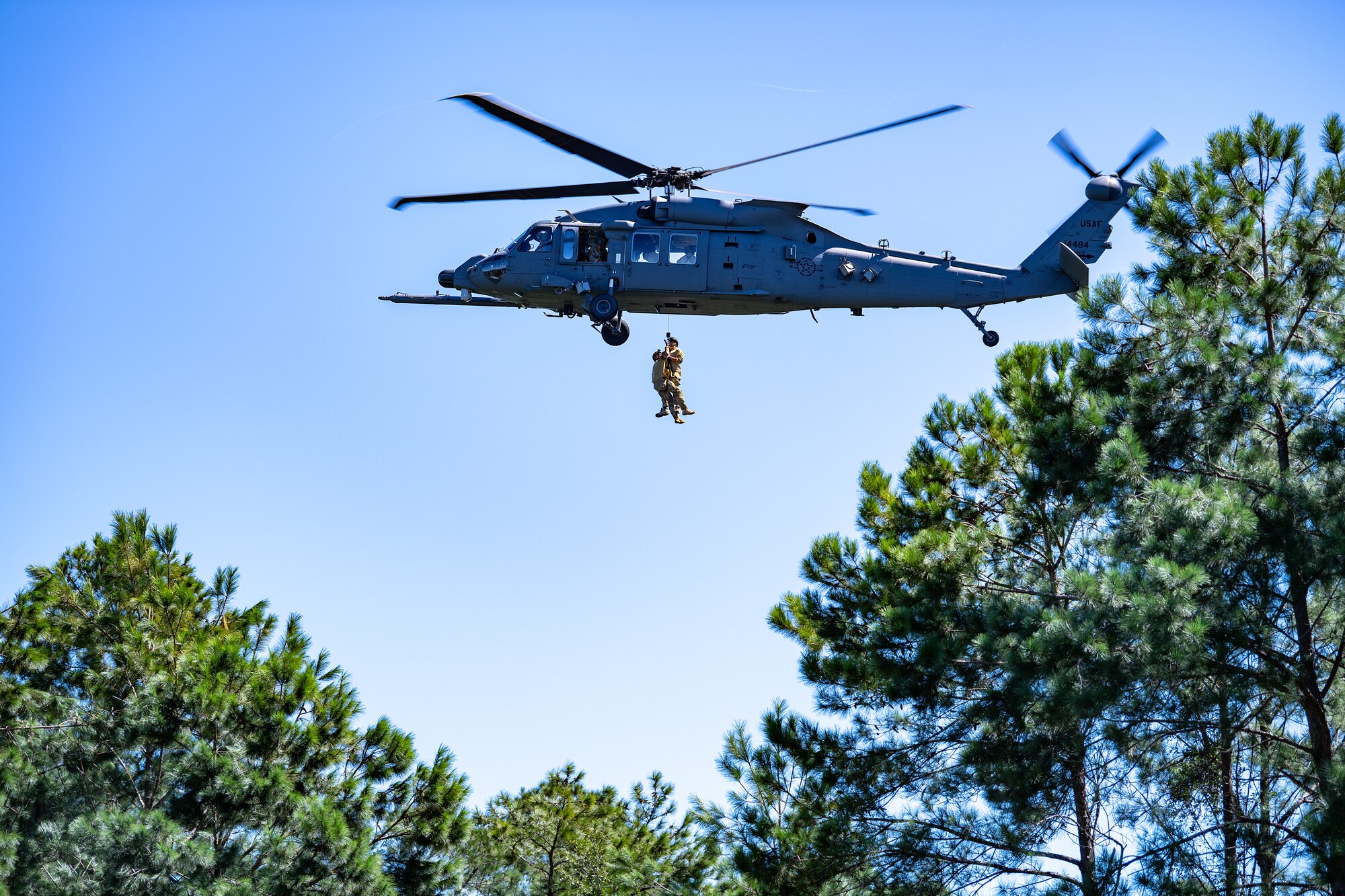 Photo of Airmen rappelling from a helicopter