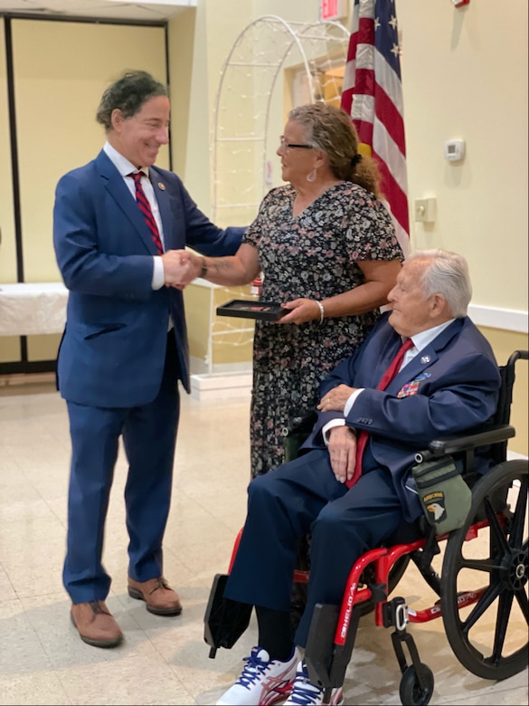 group of people standing with a man in a wheelchair.