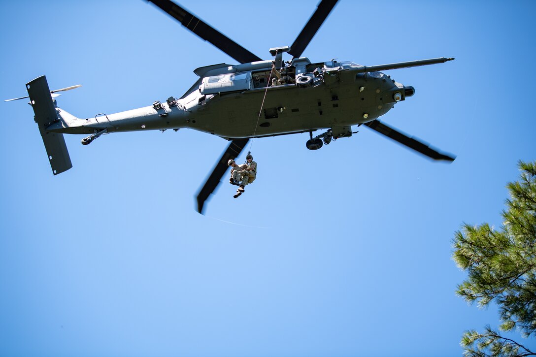 Photo of Airman rappelling from a helicopter