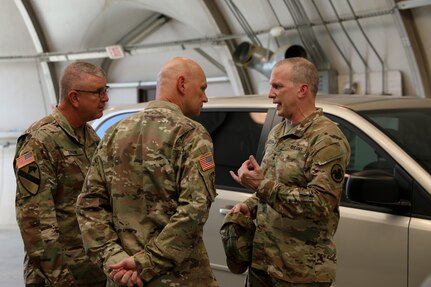Deputy Commanding General for U.S. Army Reserve Command, Maj. Gen. Gregory J. Mosser (right) speaks with U.S. Army Civil Affairs & Psychological Operations Command (Airborne) Commanding General, Brig. Gen. Jeffrey C. Coggin (left), and USACAPOC(A) Deputy Commanding General, Brig. Gen. Michael M. Greer (center), Aug. 27, 2021. Soldiers from USACAPOC(A) took part in Joint Light Tactical Vehicle (JLTV) introduction training Aug. 23-27, 2021, at the command headquarters, Fort Bragg, N.C., as part of initial JLTV fielding for the command.