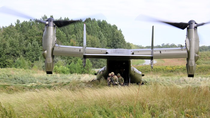 Participants exit an MV-22B Osprey to enter the simulated training village during Information Warfighter Exercise on Marine Corps Base Quantico, Va., Sep. 20, 2021. During week two, participants go through training lanes and interact with role players in order to test their skill levels in different tactical situations. IWX is a semi-annual multinational exercise designed to educate and train military service members with real-world scenarios to accomplish operations in the information environment.