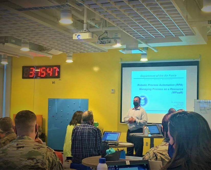 A man presents information at the front of a classroom.