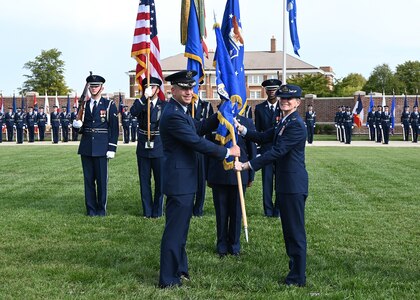 U.S. Air Force Col. Cat Logan, incoming Joint Base Anacostia-Bolling and 11th Wing commander, right, receives the 11th Wing guidon from Maj. Gen. Joel D. Jackson, Air Force District of Washington and the 320th Air Expeditionary Wing commander, during a change of command ceremony at Joint Base Anacostia-Bolling, Washington, D.C., Sept. 28, 2021. Logan took command from Col. Mike Zuhlsdorf, making her the first female commander of JBAB and the 11th Wing and the second commander of the wing at JBAB since the Air Force wing took authority of the installation during the Department of Defense’s first-ever joint base service lead transfer in 2020. (U.S. Air Force photo by Staff Sgt. Kayla White)
