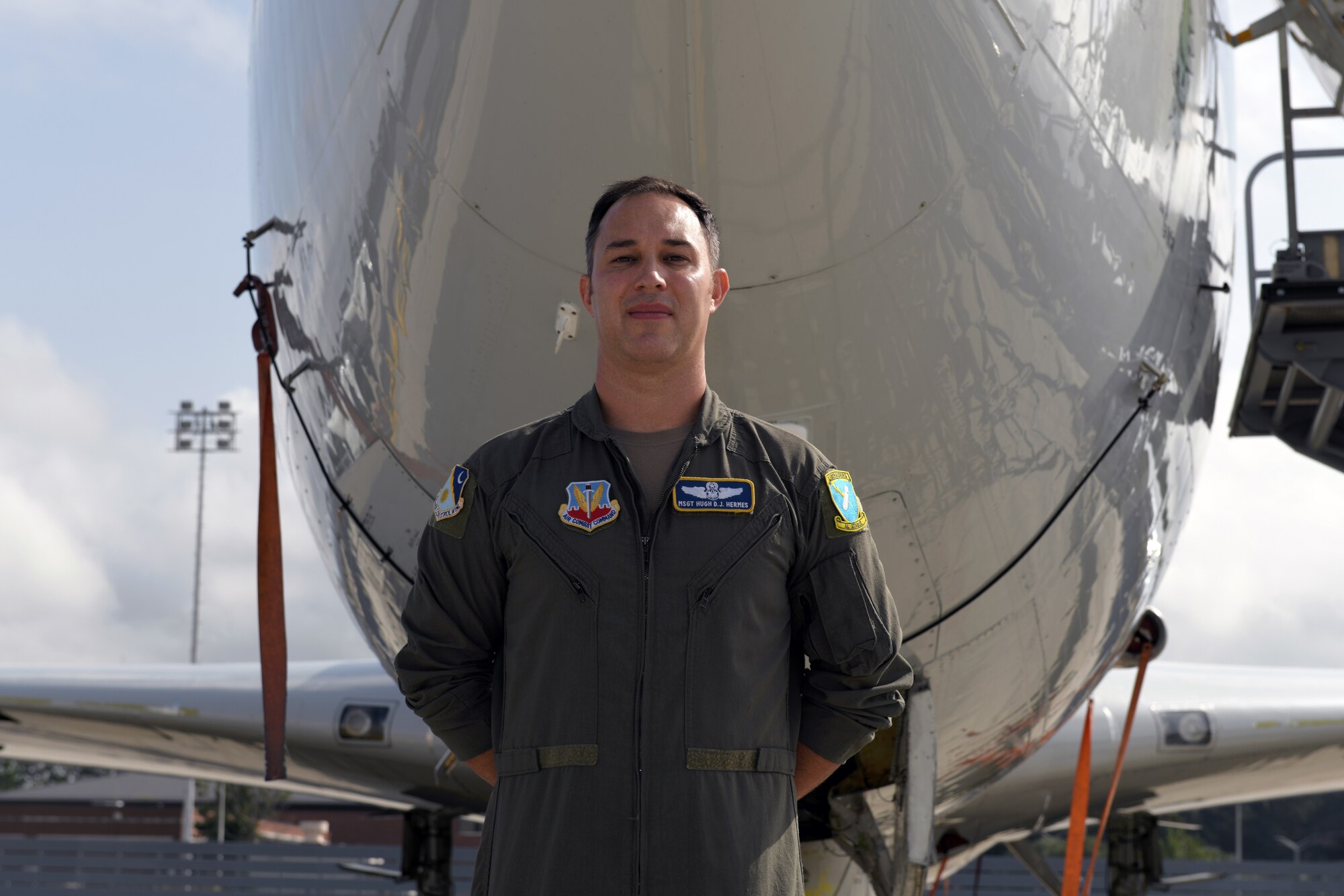 Photo shows Hermes standing in front of nose of plane.