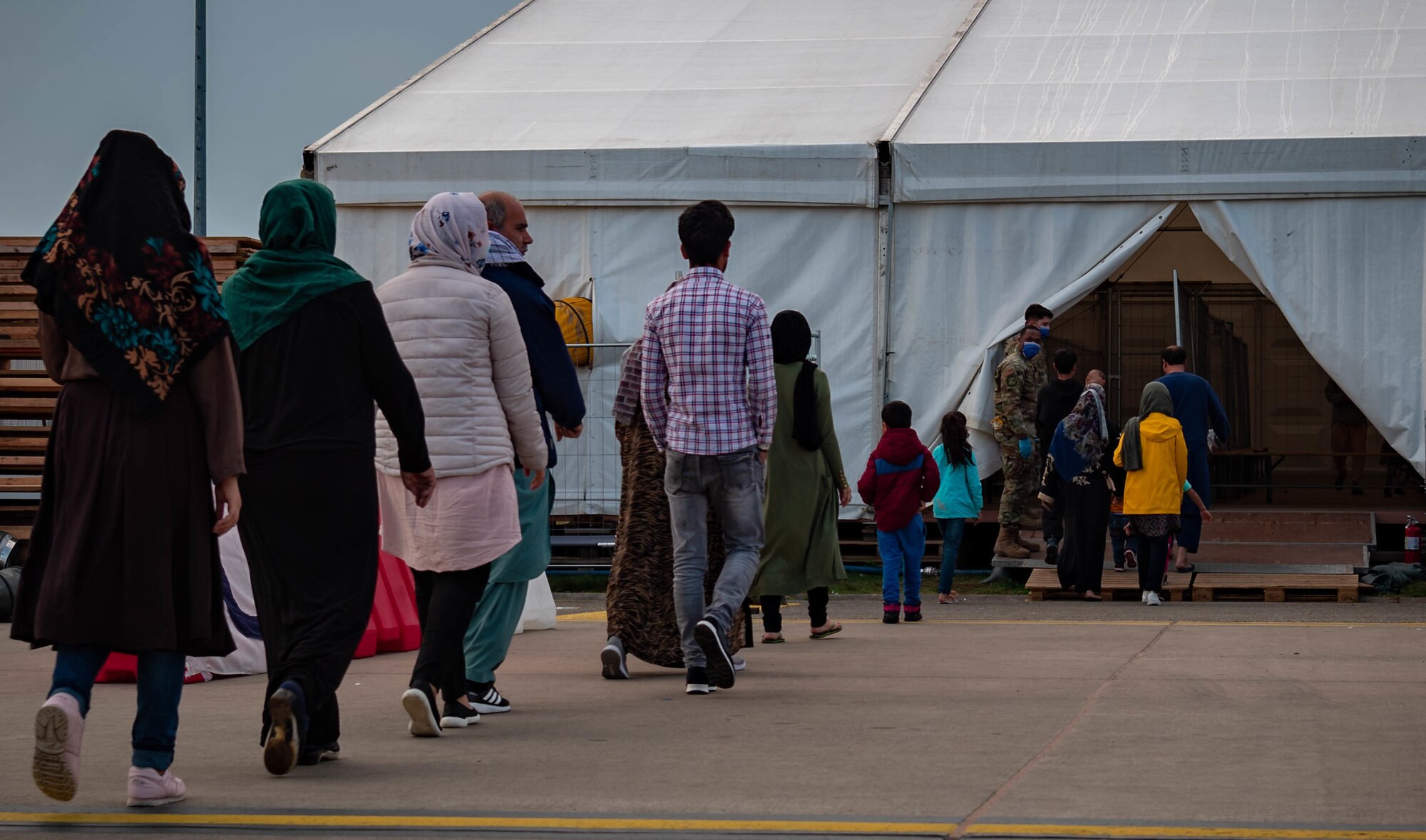 Evacuees enter a tent for vaccines.