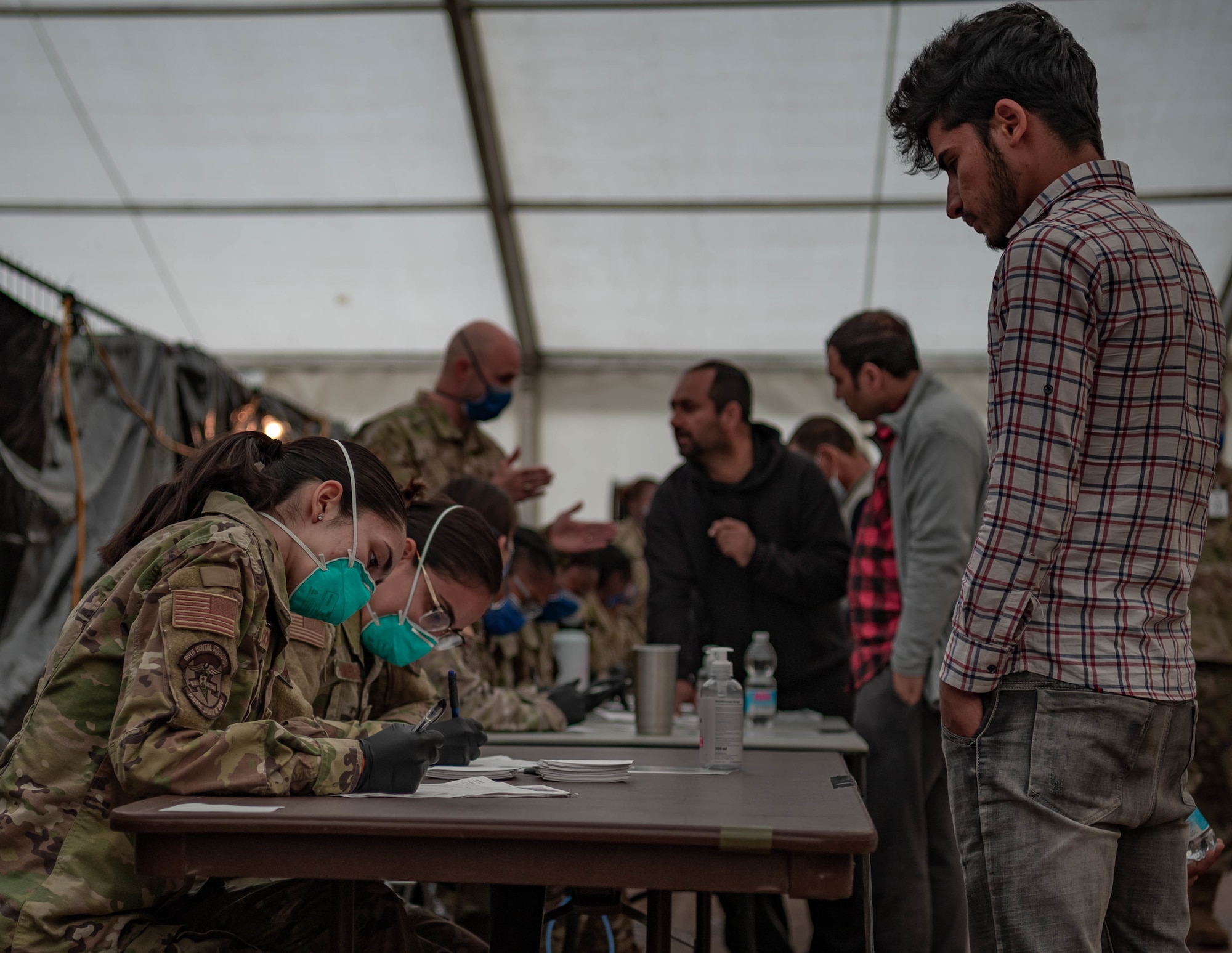 Evacuees are in-processed for vaccines.