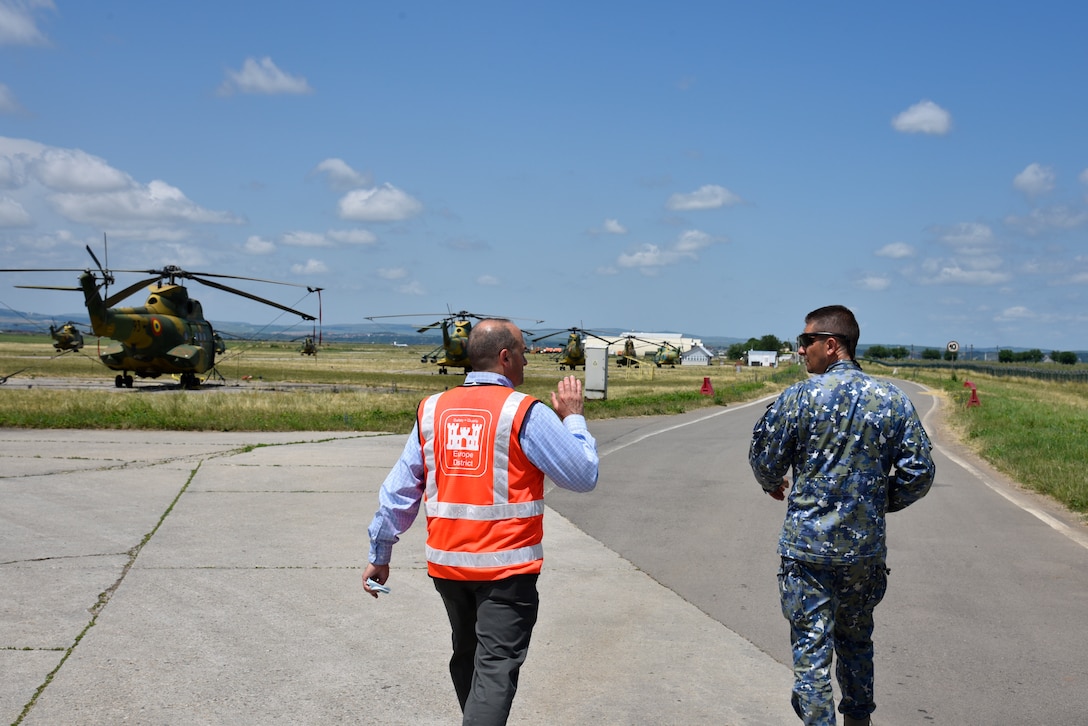 U.S. Army Corps of Engineers, Europe District Southern Europe Area Engineer Bryce Jones discusses plans for future construction projects at Campia Turzii Air Base, Romania, with Romania Air Force Chief of the Host Nation Support Office Maj. Cosmin Tanase during a site visit June 21, 2021. Jones said one of the many things he loves about supporting construction projects in Southern Europe as part of the U.S. Army Corps of Engineers is having the opportunity to work with the local partners and learn about different cultures and places.