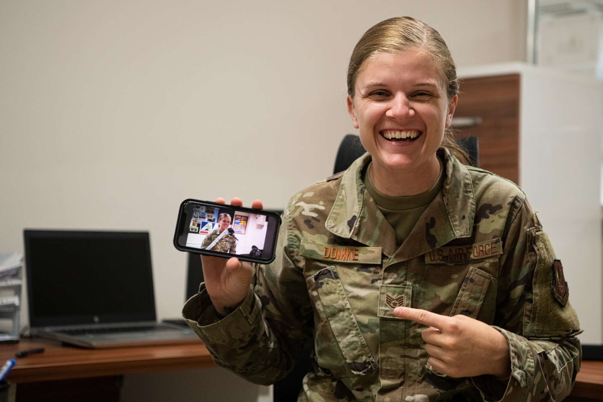 female soldier points to a photo of herself