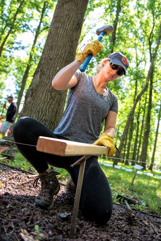 Pennsylvania Air National Guard Staff Sgt. Colette Savant, an aerospace medical technician with the 111th Medical Group here, hammers a plaque into the ground at the Medal of Honor Grove, Freedoms Foundation, Valley Forge, Pennsylvania,  June 16, 2021. Many of the plaques at the living memorial honoring recipients of our nation’s highest military decoration needed repair or moving due to overgrowth at the memorial.