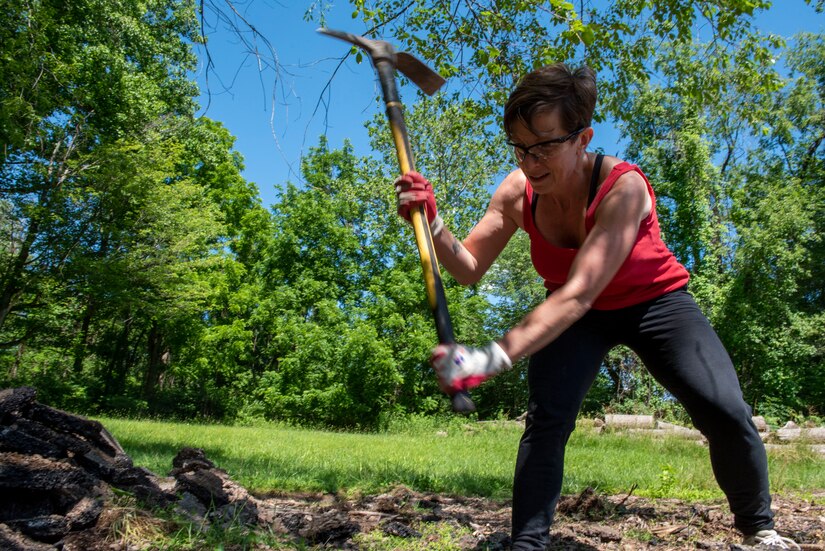 Pennsylvania Air National Guard Master Sgt. Danielle Heidrick, a command support staff specialist at the 201st Rapid Engineer Deployable, Heavy Operational Repair Squadron Detachment 1 here, uses a pickaxe to break-up blacktop at the Medal of Honor Grove, Freedoms Foundation, Valley Forge Pennsylvania, June 16, 2021. The 111th Guardsmen volunteered to help clean, organize, and remove debris with the Friends of the Medal of Honor Grove, an all-volunteer group that maintains the Medal of Honor Grove.