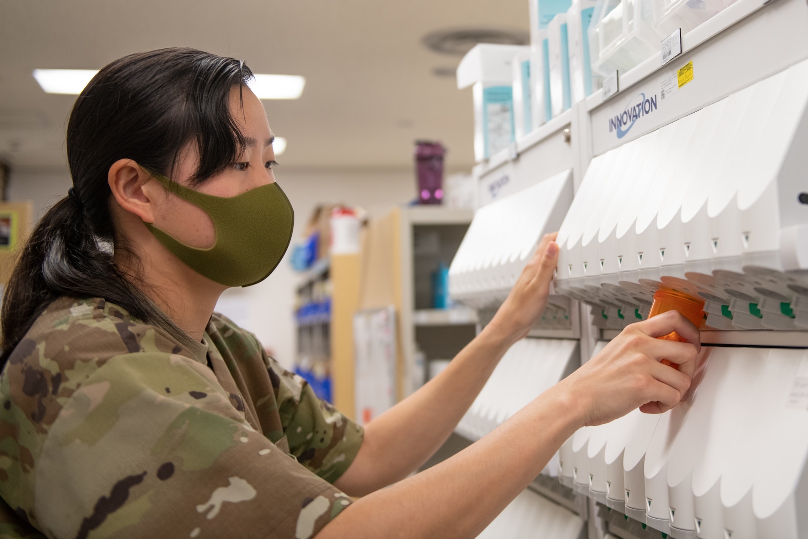 Pharmacy technician fills a prescription bottle