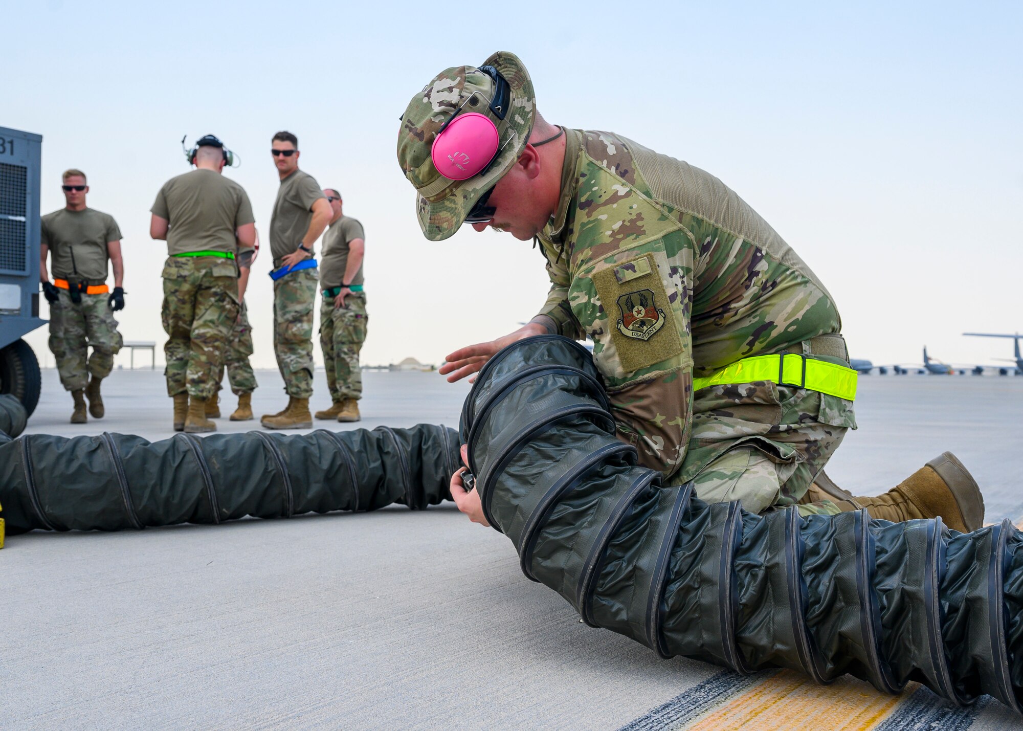 U.S. Air Force Airman 1st Class Anthony Dekancey-Winters, 378th Expeditionary Maintenance Squadron transient alert, prepares equipment necessary to hot pit refuel a U.S. Air Force KC-135 Stratotanker at Al Udeid Air Base, Qatar, Aug. 4, 2021. Hot pit refueling is where maintainers refuel an aircraft while the engine is still running, allowing the aircraft to safely and quickly return to flying. This refueling tactic is one of several agile combat employment capabilities the 378th Air Expeditionary Wing demonstrated while in Qatar for Exercise Sky Shield III, a bilateral defensive counter air and combat search and rescue exercise. (U.S. Air Force Photo by Senior Airman Samuel Earick)