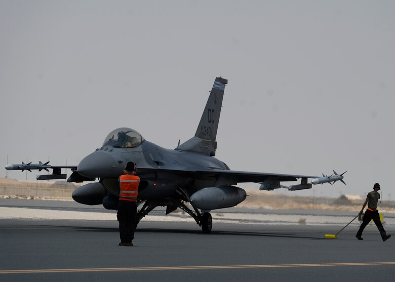 U.S. Air Force Tech. Sgt Cody Benedict, 379th Expeditionary Maintenance Squadron wheel and tire non-commissioned officer-in-charge, and U.S. Air Force Senior Airman Scott Fure, 379th EMXS C-130 crew chief, prepare a U.S. Air Force F-16CJ Fighting Falcon for a hot-pit refueling during Exercise Sky Shield III at Al Udeid Air Base, Qatar, Aug. 3, 2021. Sky Shield is a bilateral defensive counter air and combat search and rescue exercise designed to validate U.S. Air Forces Central and Qatar Emiri Air Force’s combined capability to defend regional airspace. The event allowed the 378th Air Expeditionary Wing to demonstrate its agile combat employment capabilities of repositioning forces in various locations and rapidly generating combat airpower. (U.S. Air Force photo by Senior Airman Samuel Earick)