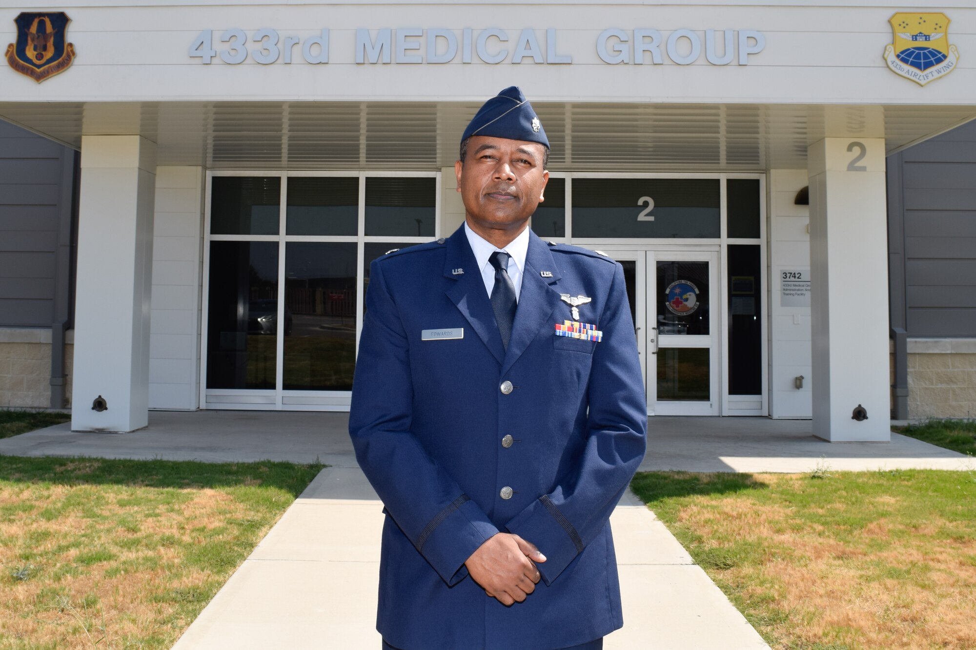 Lt. Col. Ivan Edwards, 433rd Aerospace Medicine Squadron flight surgeon, stands for a photograph at the 433rd Medical Group building on Joint Base San Antonio-Lackland, Texas, Sept. 21, 2021. Edwards emigrated from Uganda to the United States and became a physical medicine and rehabilitation physician. (U.S. Air Force photo by Senior Airman Brittany Wich)