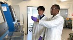 two people in lab coats using testing equipment