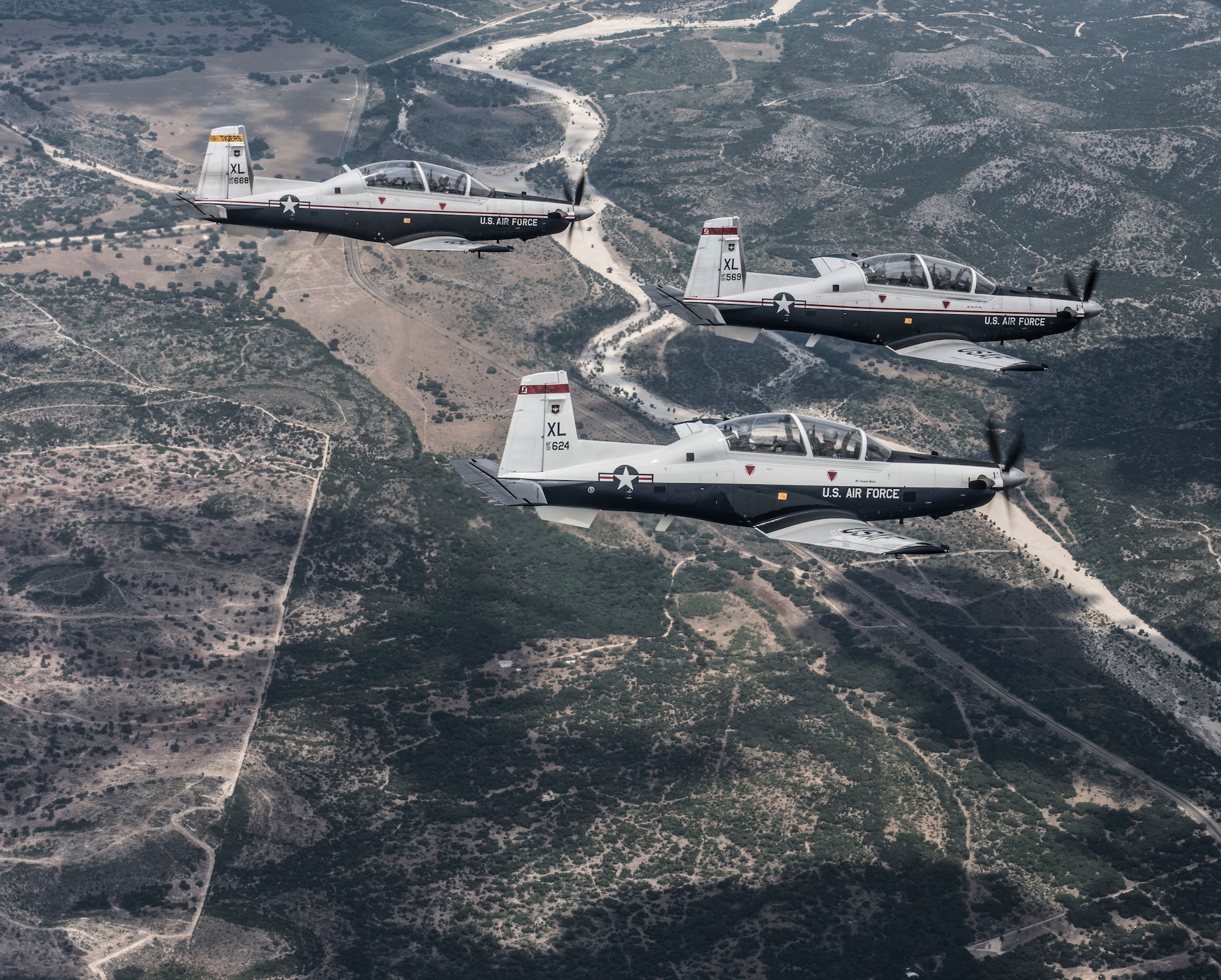 Three T-6A Texan II aircraft practice advanced aerial maneuvers in Del Rio, Texas