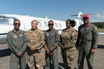 U.S. Air Force Capt. Sidney Ganison, C-21 pilot, stands next to Staff Sgt. Rachel Kinsey, Aviation Resource Management NCOIC, Capt. Johnny Frye, C-21 pilot, Master Sgt. Shina Williamson, 458th Airlift Squadron superintendent, and Capt. Kyle Green, C-21 pilot, (left to right) during a trip to Tuskegee, Alabama, Sept. 28, 2021. The group made history as being the first all-African American crew to land the C-21 at Alabama's historic Tuskegee Airfield. (U.S. Air Force photo by 1st Lt. Sam Eckholm)