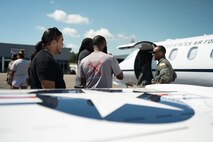 U.S. Air Force Capt. Johnny Frye, 458th Airlift Squadron, C-21 pilot, visits with students from the Red Tail Flight Academy during a trip to Tuskegee, Alabama, Sept. 28, 2021. The group of pilots from Scott AFB, Illinois made history as being the first all-African American crew to land the C-21 at Alabama's historic Tuskegee Airfield. (U.S. Air Force photo by 1st Lt. Sam Eckholm)